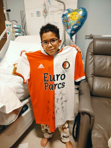 Logan in het ziekenhuis met een gekregen Feyenoordshirt